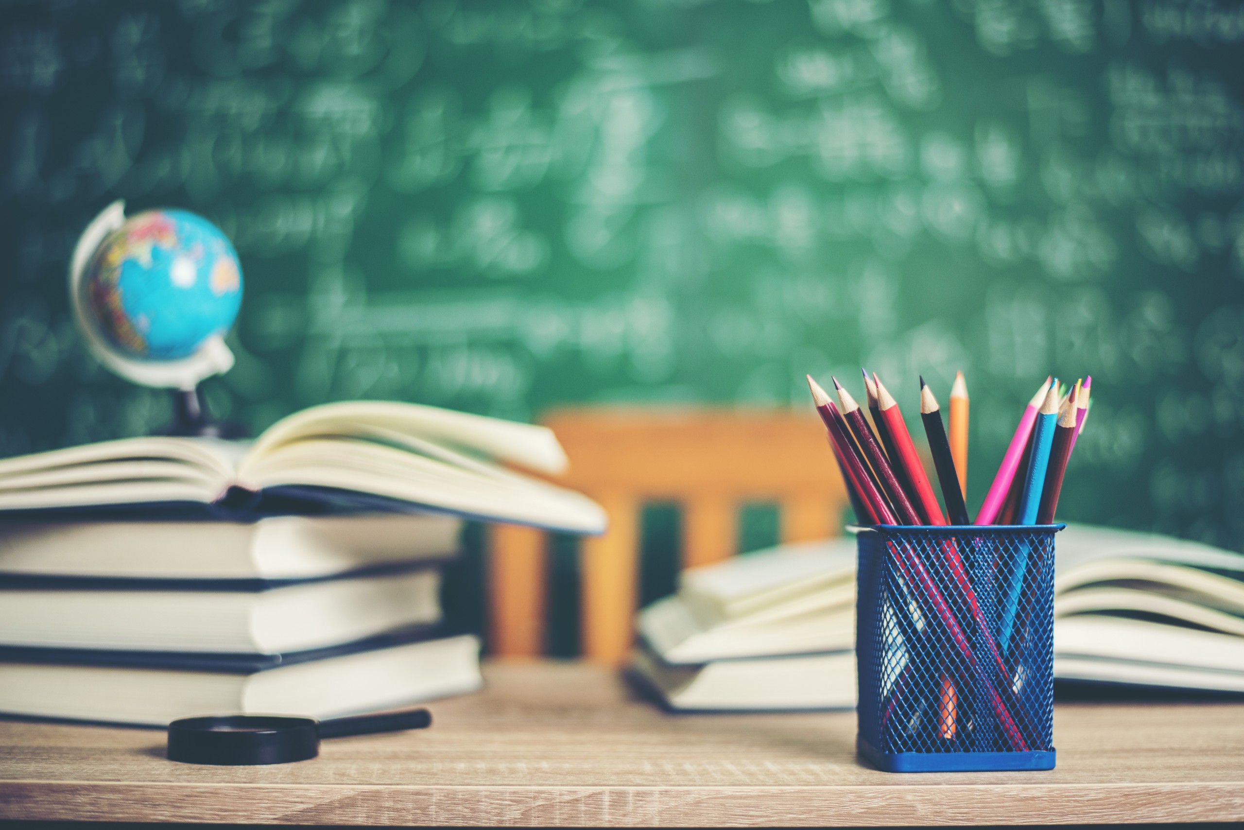 Education blackboard school supplies blurred teacher pencils
