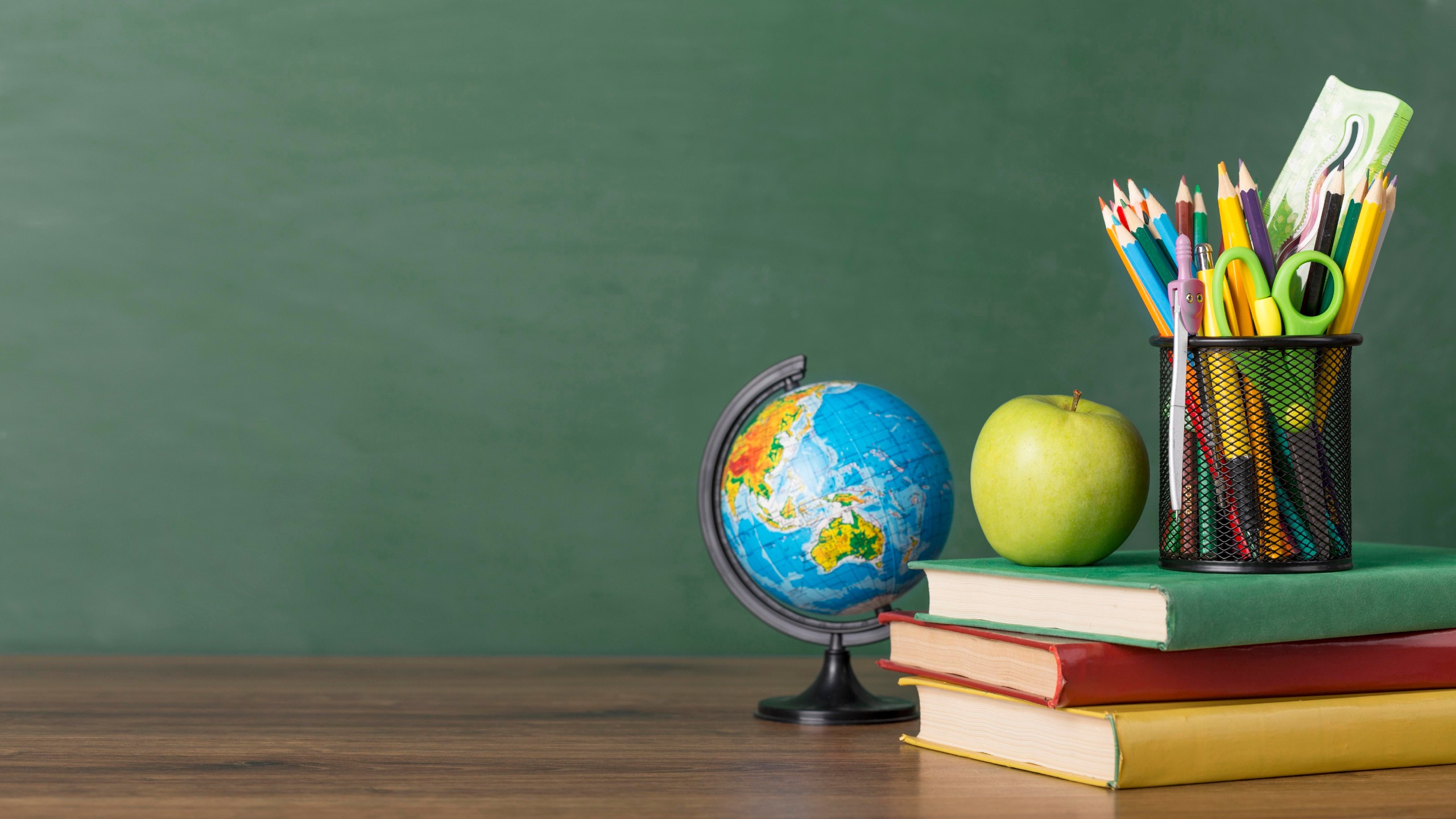 Img education desk teacher books apple pencils globe